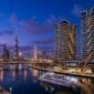 Binghatti Skyrise luxury waterfront towers overlooking the Dubai Water Canal at dusk.