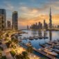 Dubai Creek Harbour waterfront promenade and luxury yachts overlooking Downtown Dubai Burj Khalifa skyline at dusk