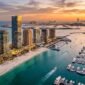 Aerial view of EMAAR Beachfront luxury towers and superyacht marina in Dubai Harbour at sunset.