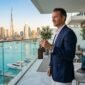 Successful investor holding keys on luxury Dubai penthouse balcony with skyline views, illustrating post-handover payment plan ROI.
