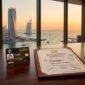 UAE 10-year Golden Visa residency card and official DLD real estate ownership deed on executive desk overlooking Dubai coastline.
