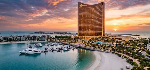 Wynn Al Marjan Island luxury casino resort tower, marina, and beachfront residences at sunset in Ras Al Khaimah